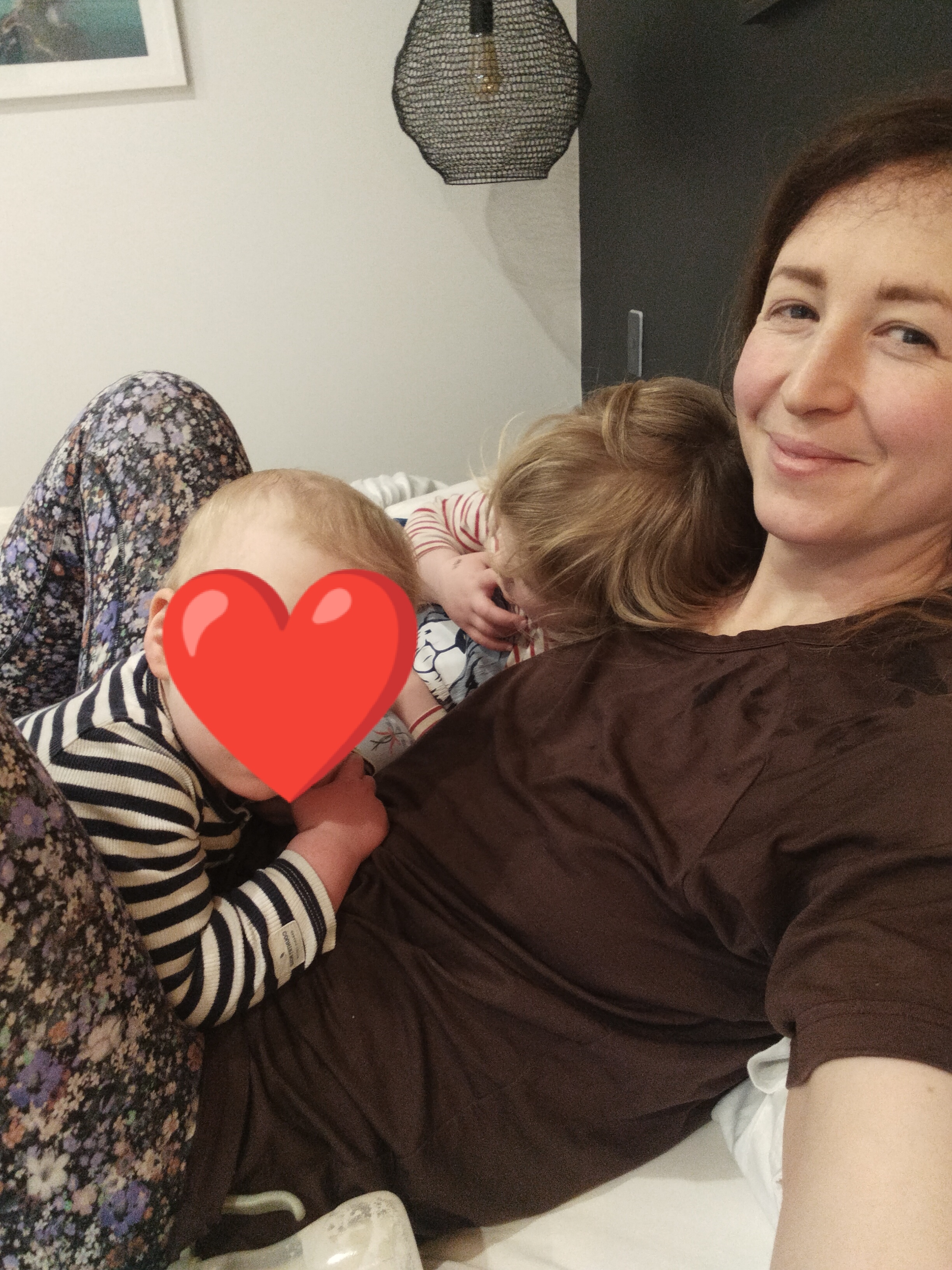 Abby resting on a bed with her two children